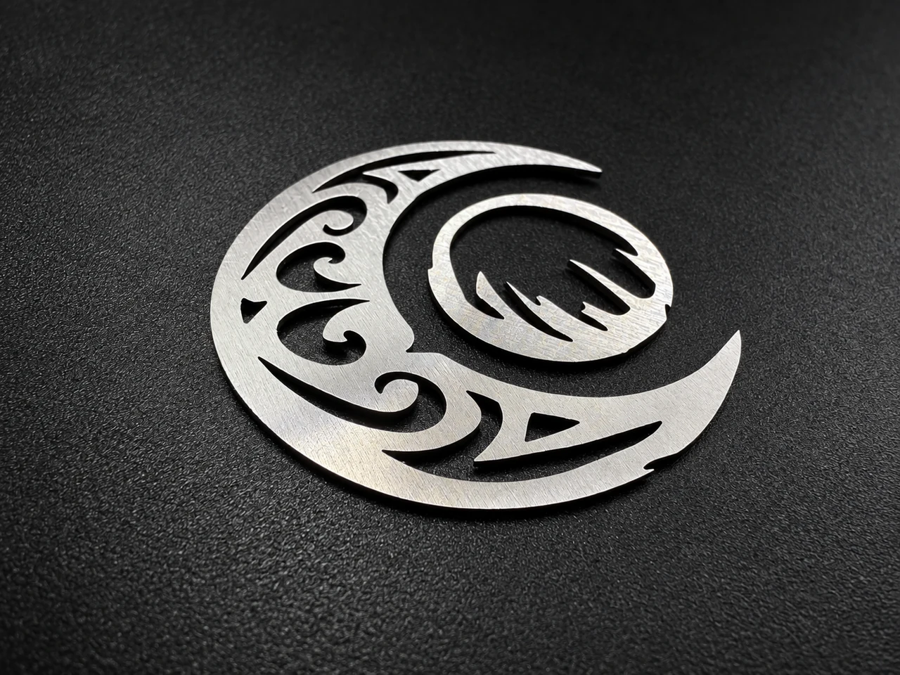 Two decorative metal shapes with curved outlines and intricate internal cut-outs