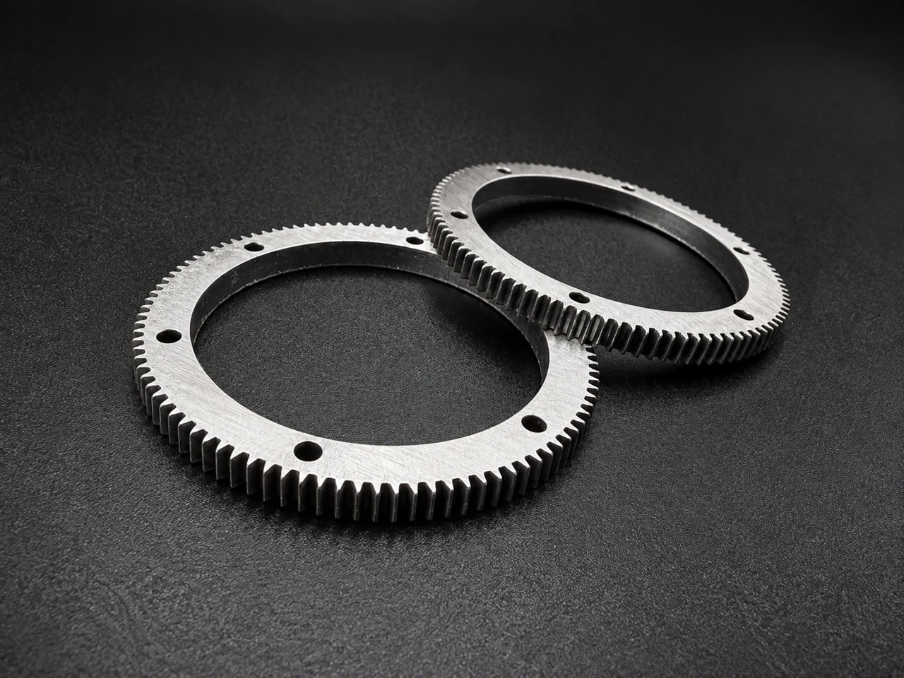 Two circular metal rings with toothed outer edges and evenly spaced holes