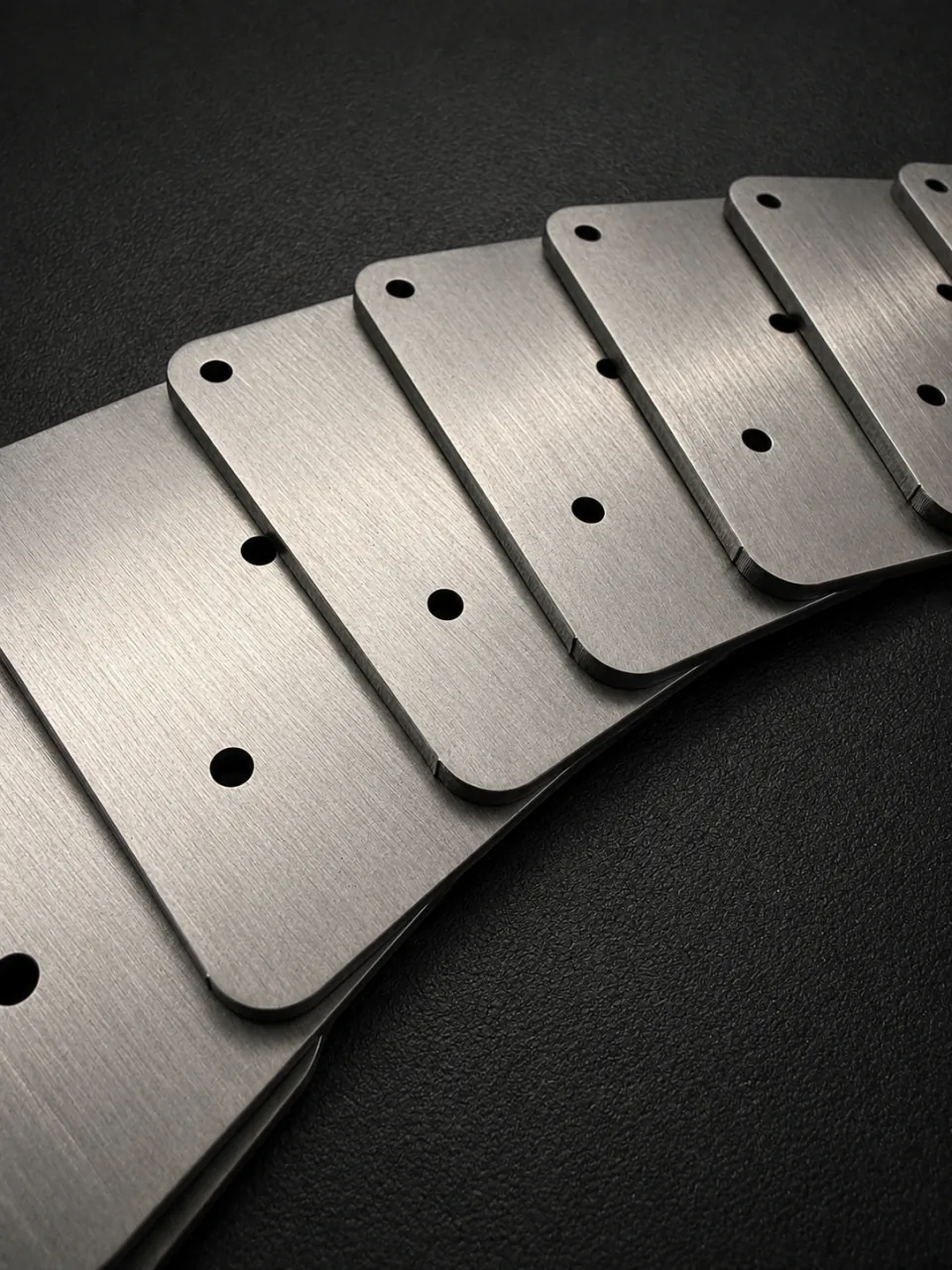A batch of rectangular metal plates with rounded corners and two fixing holes